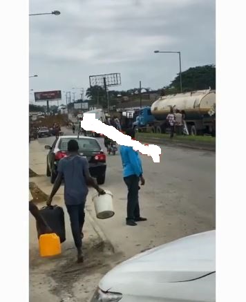 People scooping fuel from faulty tanker